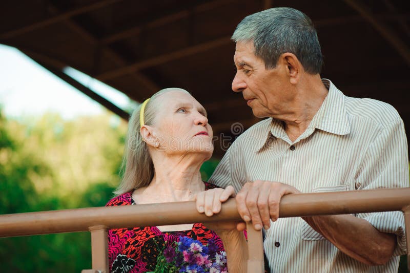 Everyday Life With An Older Girlfriend Embrace and Kiss of Old Couple in a Park on a Sunny Day. Stock Image