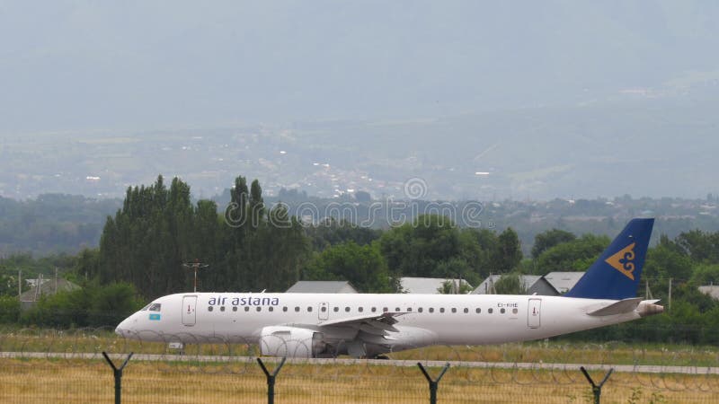 Embraer e190 air astana taxiing στην πλαϊνή όψη του αερολιμένα almaty απόθεμα βίντεο
