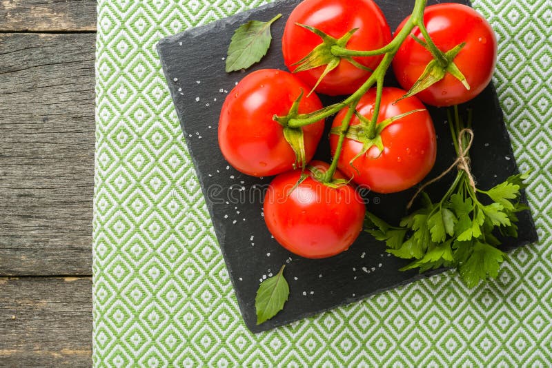 Embranchez-vous avec cinq tomates rouges mûres Gouttes de l'eau sur les fruits mûrs Feuilles et tronc de vert photographie stock Embranchez-vous avec cinq tomates rouges mûres Gouttes de l'eau sur les fruits mûrs Feuilles et tronc de vert photographie stock