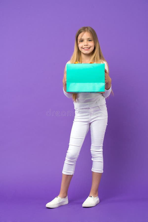 Embrome al comprador en ropa de sport en el fondo violeta Pequeño niño con el panier Sonrisa feliz de la muchacha con la bolsa de fotos de archivo libres de regalías Embrome al comprador en ropa de sport en el fondo violeta Pequeño niño con el panier Sonrisa feliz de la muchacha con la bolsa de fotos de archivo libres de regalías