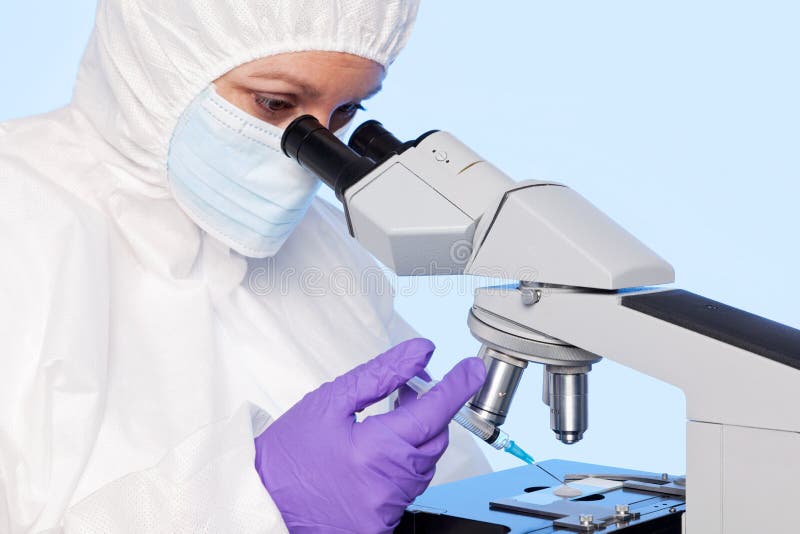 Embryologist che estrae un campione per mezzo di una siringa.