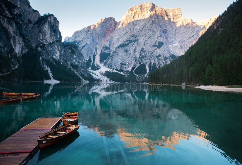 Emerald Mountain Lake Braies. boat station. Wooden pier. Morning landscape in Italy