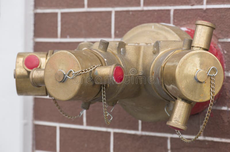 Emergency fire extinguisher water hydrant pipe on brick wall. stock images