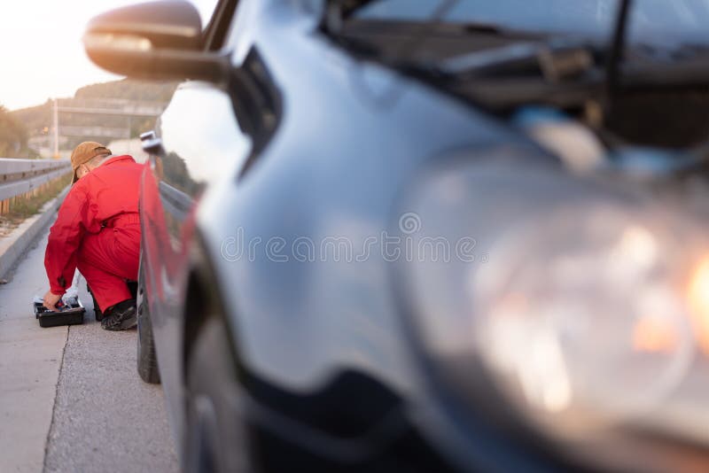 Emergency Roadside Assistance, Road Assistance Worker in Uniform Trying