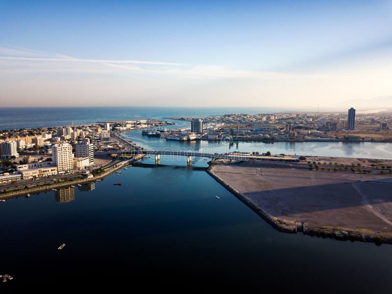 Ras al Khaimah emirate in the UAE aerial skyline view. At sunset, creek, water, united, arab, emirates, rak, lake, tower, cityscape, cornish, residential, desert, middle, east, business, park, sea, road, sunrise, traffic, bridge, calm, mangrove, corniche, building, downtown, skyscraper, urban, bay, landmark, north, district, boat, gulf, arabic, wide, seaside, julphar. Ras al Khaimah emirate in the UAE aerial skyline view. At sunset, creek, water, united, arab, emirates, rak, lake, tower, cityscape, cornish, residential, desert, middle, east, business, park, sea, road, sunrise, traffic, bridge, calm, mangrove, corniche, building, downtown, skyscraper, urban, bay, landmark, north, district, boat, gulf, arabic, wide, seaside, julphar