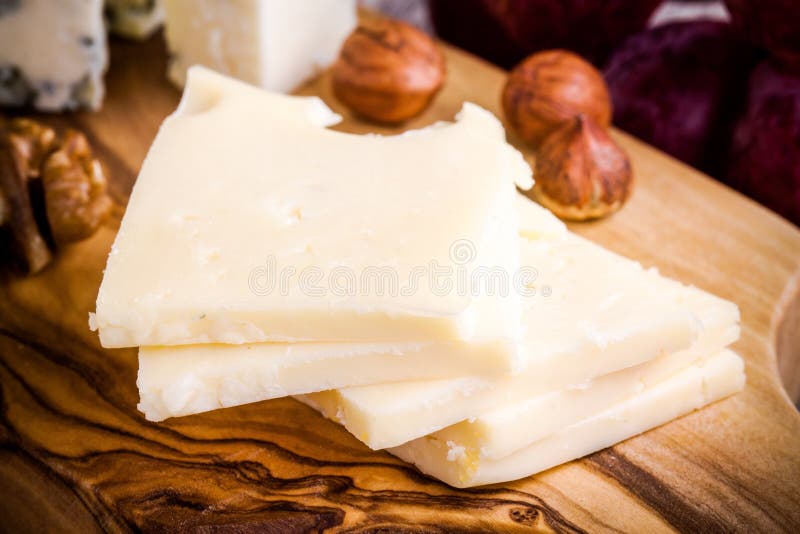 Emmentalerostnärbild med muttrar på ett träbräde royaltyfri foto Emmentalerostnärbild med muttrar på ett träbräde royaltyfri foto