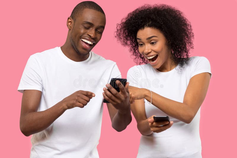 Emocionada pareja afroamericana usando teléfono móvil, leyendo buenas noticias