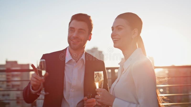 Emocionantes colegas celebrando la azotea al atardecer. Hombre sonriente foto de archivo