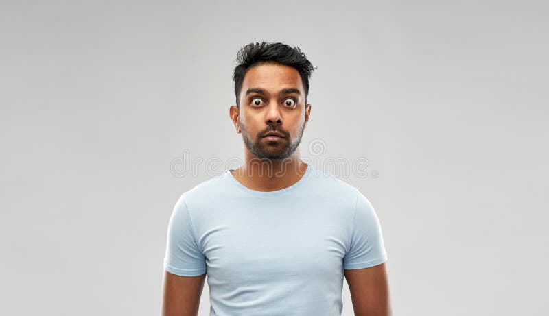 Shocked or scared man over grey background.