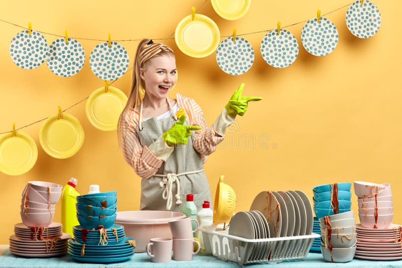 Emotional awesome fair-haired woman showing her clean plates on the clothespins royalty free stock photography Emotional awesome fair-haired woman showing her clean plates on the clothespins royalty free stock photography