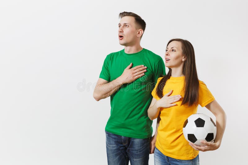 Emotional couple, woman man, football fans in yellow green t-shirt cheer up support team with soccer ball singing royalty free stock photo Emotional couple, woman man, football fans in yellow green t-shirt cheer up support team with soccer ball singing royalty free stock photo