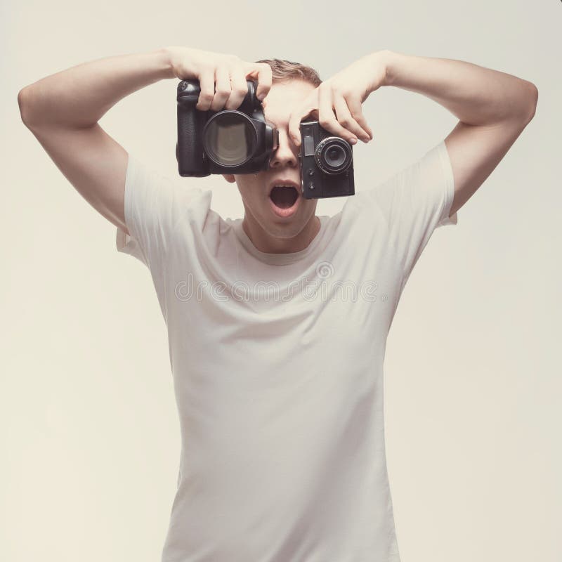 Emotional Man with camera isolated on light background. Young man hold digital camera and old tape camera. Lifestyle, travel and stock photos Emotional Man with camera isolated on light background. Young man hold digital camera and old tape camera. Lifestyle, travel and stock photos