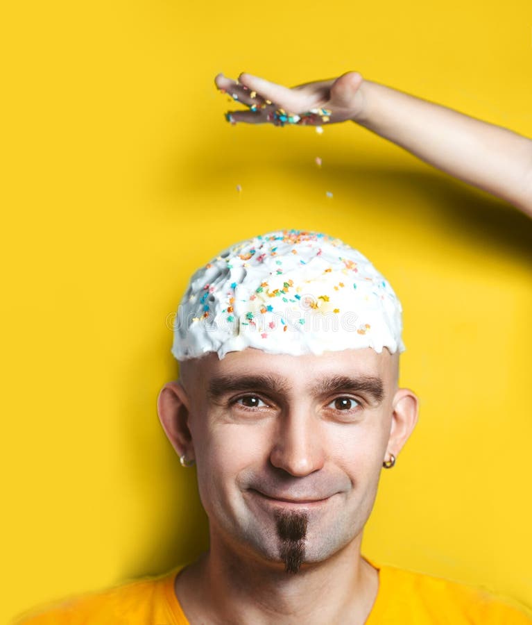 Emotional portrait of surprised bald man with easter cake on his head. Funny Easter concept.