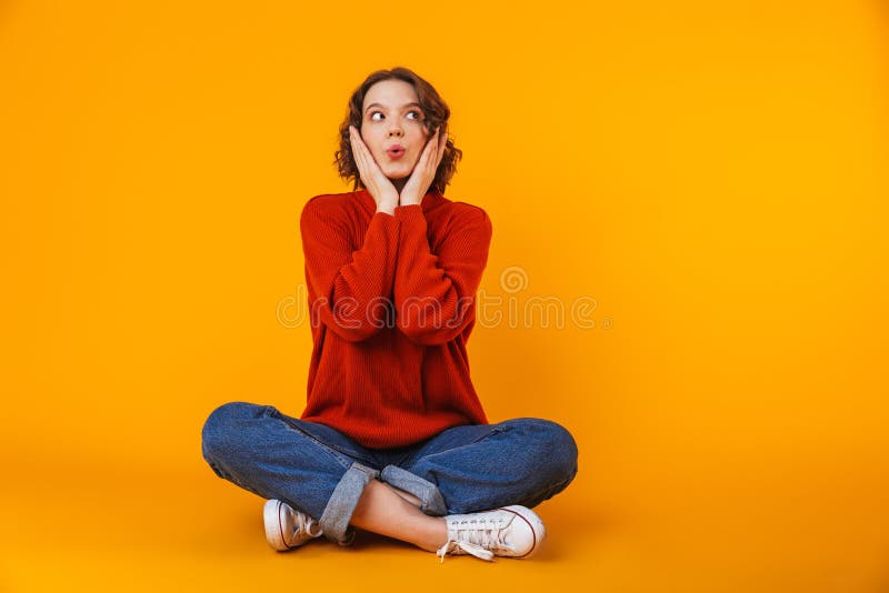 Emotional shocked young pretty woman posing over yellow wall background stock photography Emotional shocked young pretty woman posing over yellow wall background stock photography