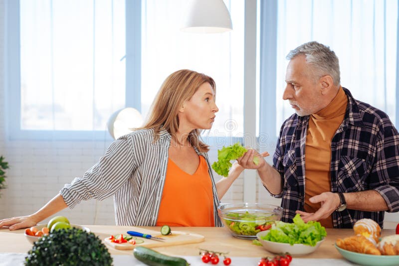 Emotionale Paare, die Argument beim Kochen des Salats für das Mittagessen haben stockbilder Emotionale Paare, die Argument beim Kochen des Salats für das Mittagessen haben stockbilder