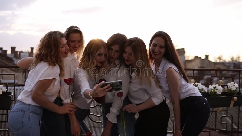 Emotionell brudtärna och attraktiva flickvänner som talar selfie med mobiltelefonen och att le Caucasian flickor i vit