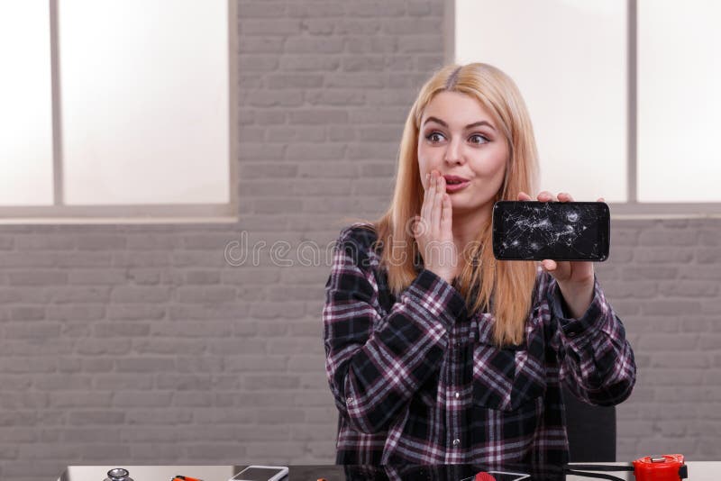 Emotionell flicka som rymmer en bruten smartphone arkivfoton Emotionell flicka som rymmer en bruten smartphone arkivfoton