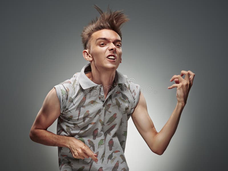 Emotional portrait of a teenager playing on air guitar on a gray background. Emotional portrait of a teenager playing on air guitar on a gray background