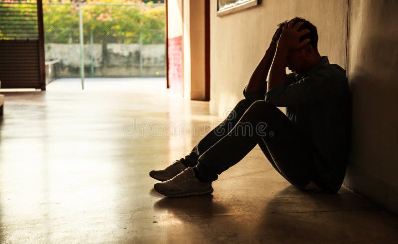 Emotionellt ögonblick: man det hållande huvudet för sammanträde i händer, den stressade ledsna unga mannen som har mentala proble fotografering för bildbyråer