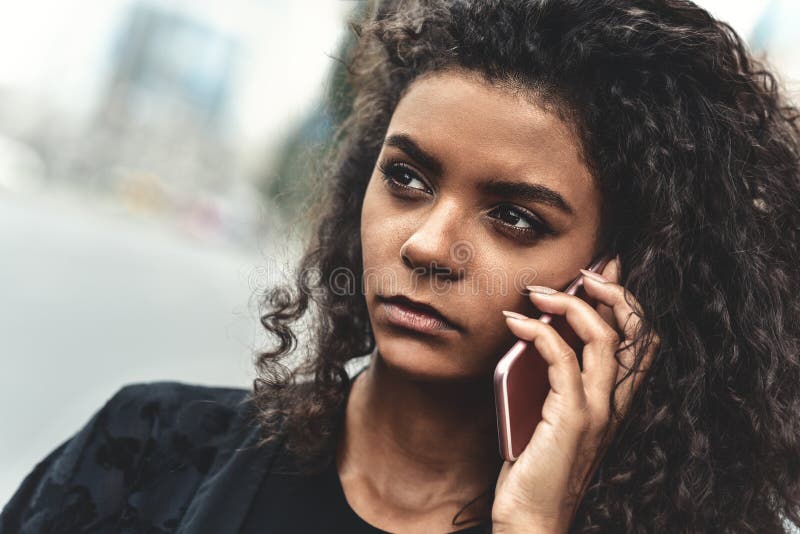 Emozioni negative Concetto di stile di vita Fine su di giovane uso della donna della corsa mista un telefono fotografia stock libera da diritti Emozioni negative Concetto di stile di vita Fine su di giovane uso della donna della corsa mista un telefono fotografia stock libera da diritti