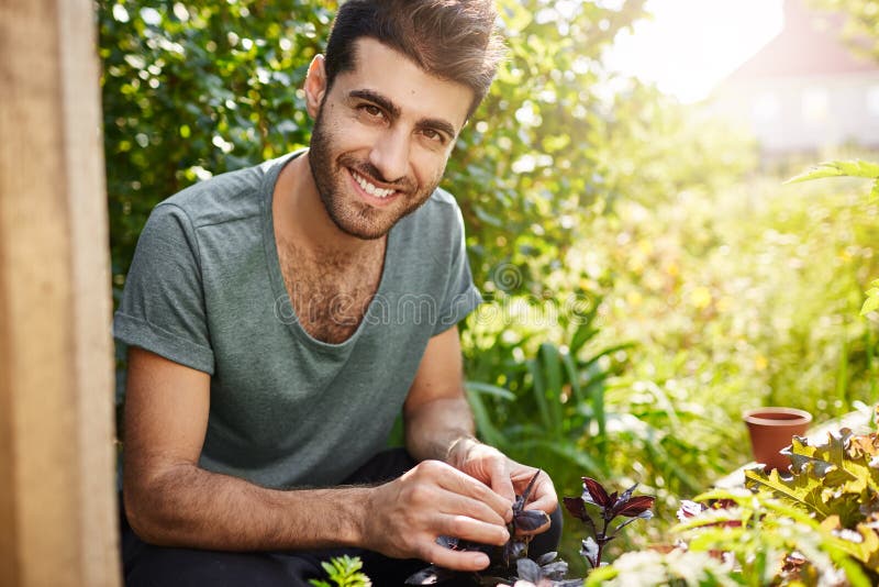 Emoções positivas, estilo de vida do campo Retrato exterior do fazendeiro latino-americano farpado novo que sorri com dentes, tra imagens de stock royalty free Emoções positivas, estilo de vida do campo Retrato exterior do fazendeiro latino-americano farpado novo que sorri com dentes, tra imagens de stock royalty free