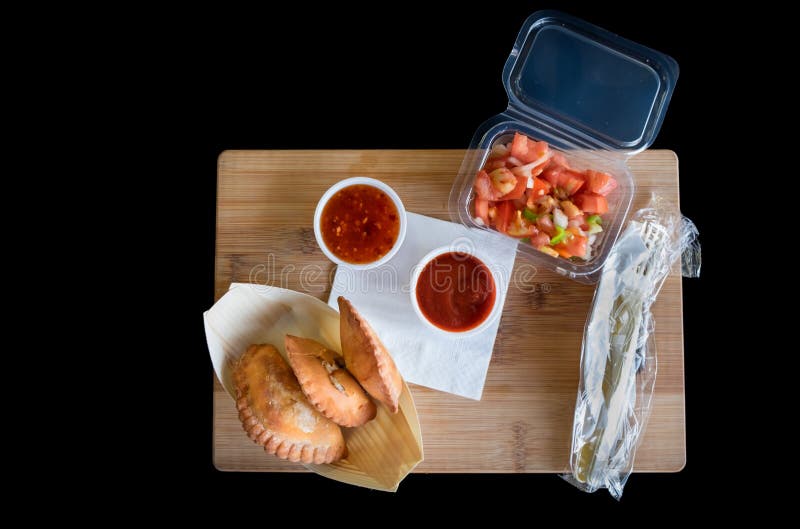 Empanadas, salada picante e molhos na placa cortada de madeira de bambu fotografia de stock Empanadas, salada picante e molhos na placa cortada de madeira de bambu fotografia de stock