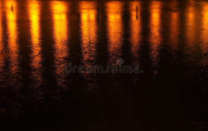 Empañe la luz anaranjada de la reflexión en agua en la noche foto de archivo libre de regalías Empañe la luz anaranjada de la reflexión en agua en la noche foto de archivo libre de regalías