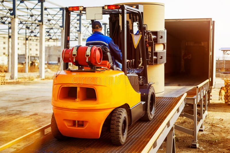 A empilhadeira está pondo a carga do armazém para transportar fotografia de stock A empilhadeira está pondo a carga do armazém para transportar fotografia de stock