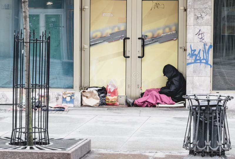 Emplacement sans abri d'homme en temps froid à la boutique fermée de porte dans Wrocl photos stock Emplacement sans abri d'homme en temps froid à la boutique fermée de porte dans Wrocl photos stock