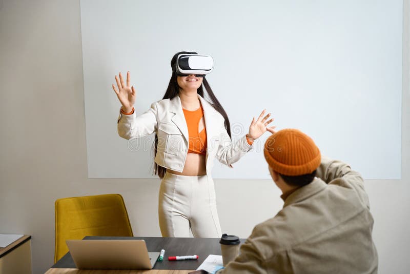 Empleada femenina en formación de realidad virtual supervisada por un colega imagen de archivo