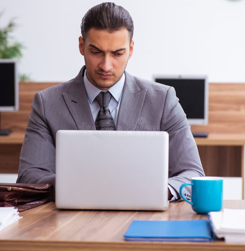 Empleado joven descontento con el trabajo excesivo imagen de archivo