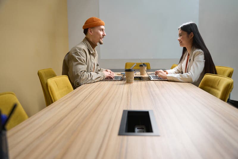 Empleados de la empresa con portátiles que se comunican en la sala de reuniones imagen de archivo libre de regalías
