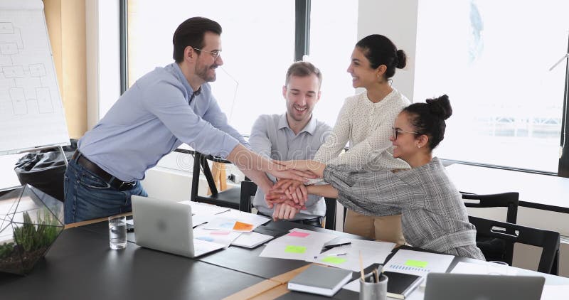 Empleados multirraciales felices que muestran el espíritu de equipo y asistencia.