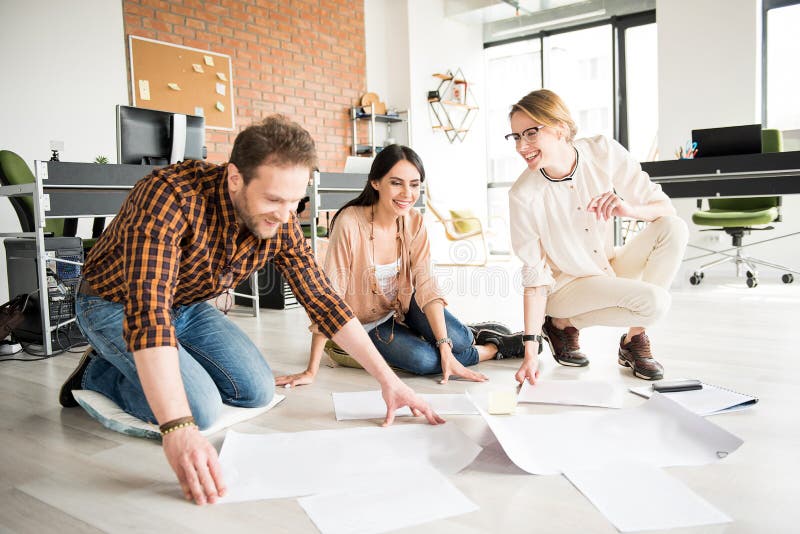 Empleados sonrientes alegres que trabajan junto imagenes de archivo Empleados sonrientes alegres que trabajan junto imagenes de archivo