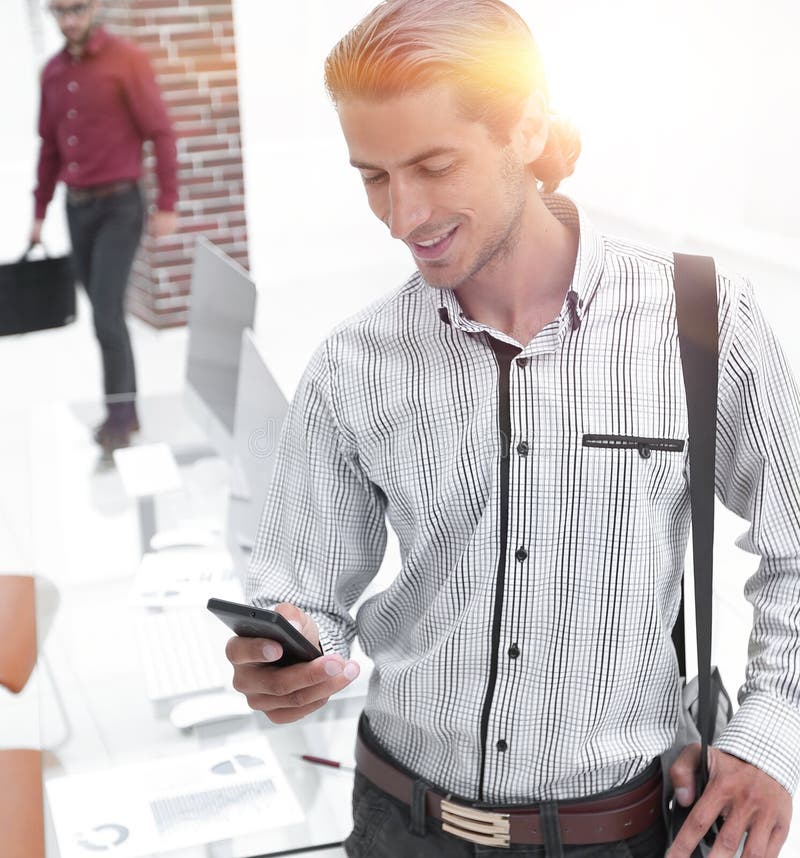 Employee reads a text message on smartphone stock photos