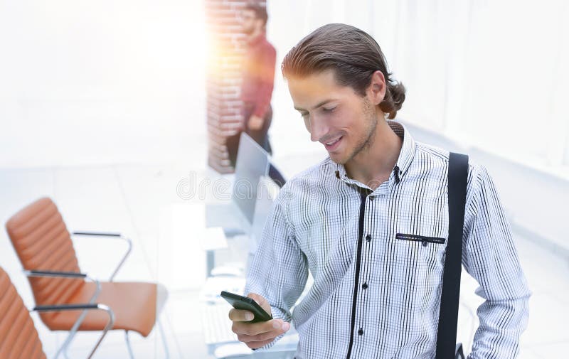 Employee reads a text message on smartphone stock image