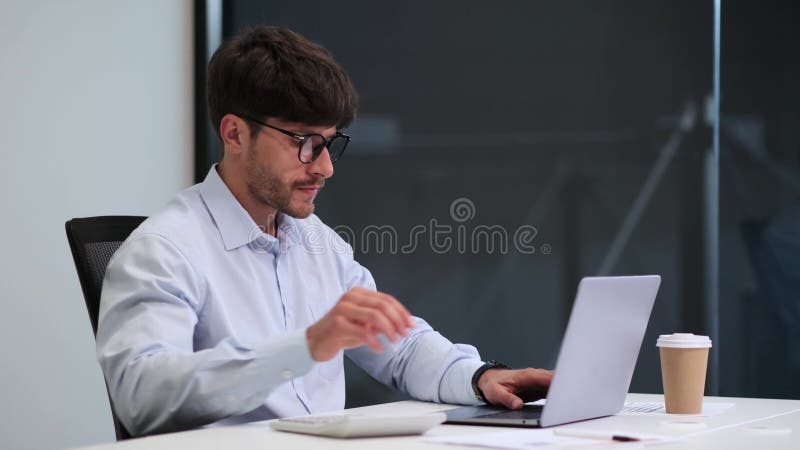 Employee Typing on Laptop and Using Calculator at Desk stock footage
