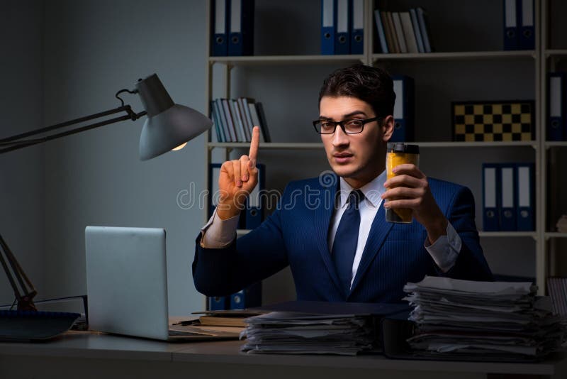 The Employee Working Late And Drinking Strong Coffee To Stay Awake