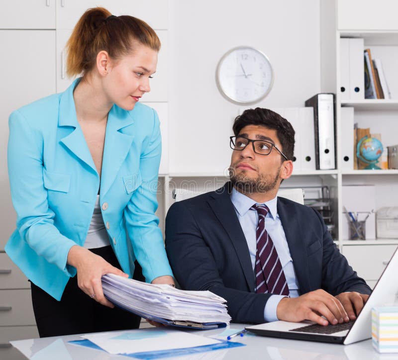 Office worker shocked by huge stack of papers brought by his boss. Office worker shocked by huge stack of papers brought by his boss