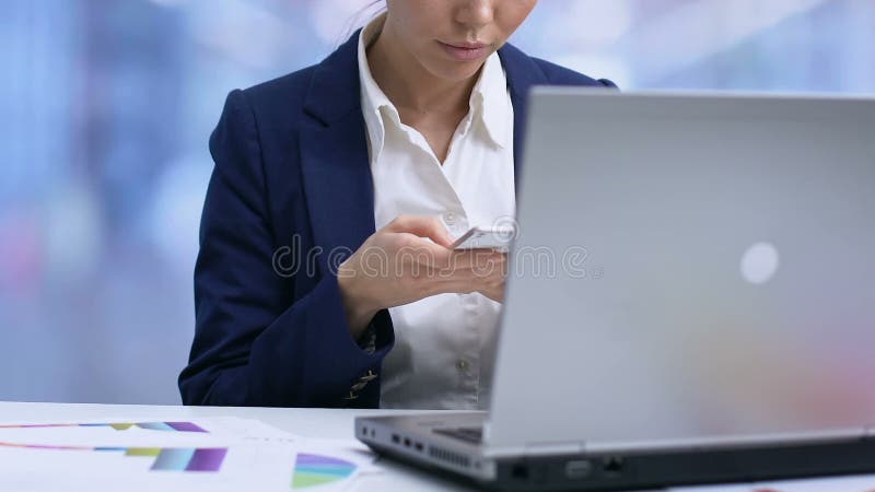 Employé de bureau dactylographiant sur le smartphone, utilisant l'outil encaissant mobile, graphiques sur la table banque de vidéos