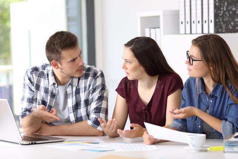 Employés ayant une conversation du travail au bureau photo stock