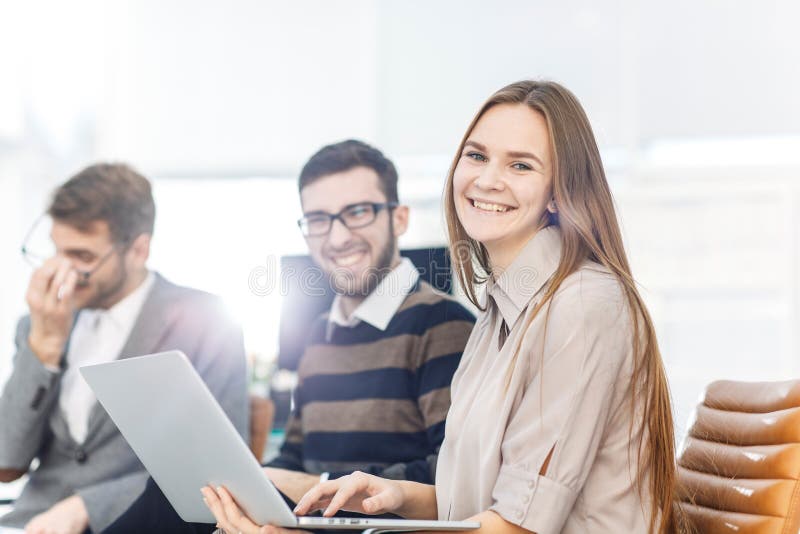 Employés du ` s de société avec un ordinateur portable se reposant dans le lobby du bureau moderne image stock Employés du ` s de société avec un ordinateur portable se reposant dans le lobby du bureau moderne image stock