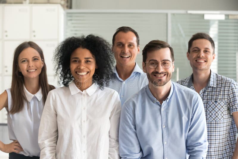 Employés professionnels multiraciaux heureux regardant la caméra, équipe