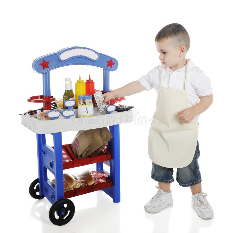 An adorable preschooler storing his hot dog stand income in a money can. The stand's signs are left blank for your text. On a white background. An adorable preschooler storing his hot dog stand income in a money can. The stand's signs are left blank for your text. On a white background.