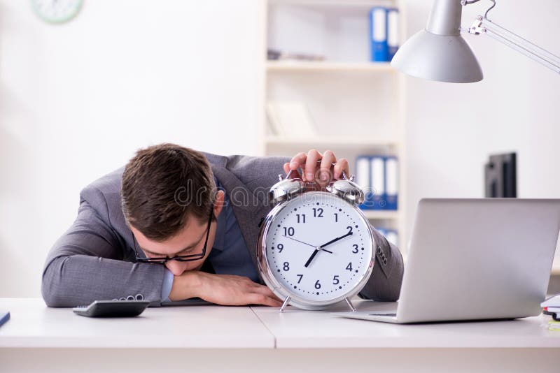 Empregado do homem de negócios no conceito da urgência e do fim do prazo com alarme imagens de stock Empregado do homem de negócios no conceito da urgência e do fim do prazo com alarme imagens de stock