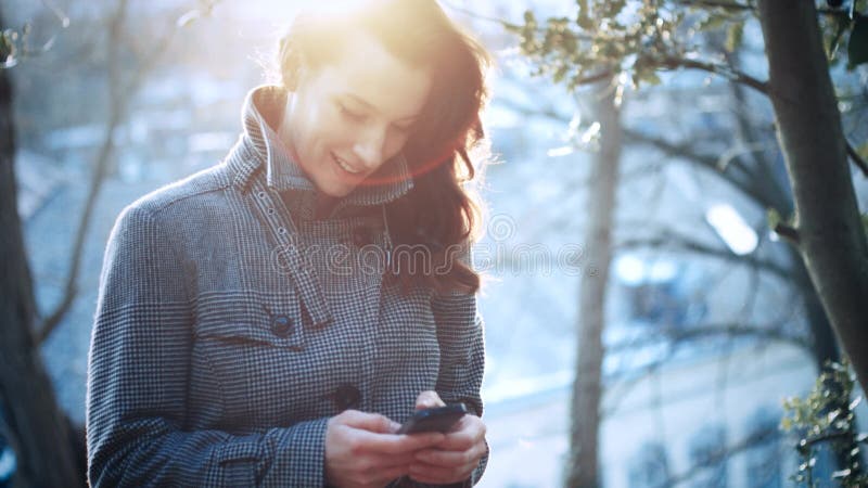 Empresaria atractiva al aire libre con el teléfono móvil