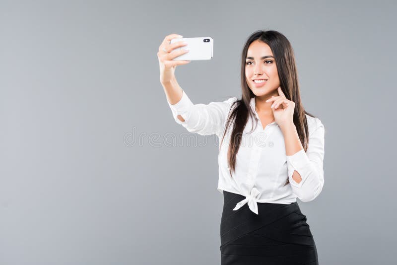 Empresaria feliz que hace la foto del selfie en smartphone o que hace la llamada video sobre el fondo blanco fotos de archivo libres de regalías Empresaria feliz que hace la foto del selfie en smartphone o que hace la llamada video sobre el fondo blanco fotos de archivo libres de regalías