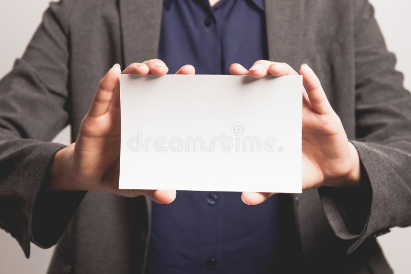 Empresaria joven que sostiene la tarjeta en blanco del negocio fotografía de archivo libre de regalías Empresaria joven que sostiene la tarjeta en blanco del negocio fotografía de archivo libre de regalías