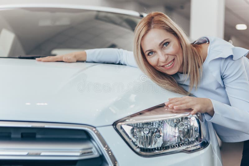 Empresaria madura que elige el nuevo automóvil en la representación imagen de archivo libre de regalías Empresaria madura que elige el nuevo automóvil en la representación imagen de archivo libre de regalías