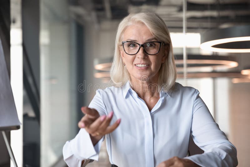 Empresaria madura que mira la cámara y hablar, haciendo la llamada video imágenes de archivo libres de regalías Empresaria madura que mira la cámara y hablar, haciendo la llamada video imágenes de archivo libres de regalías